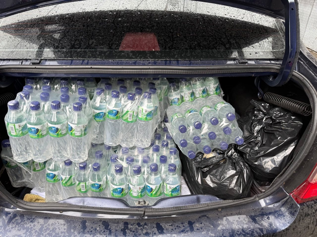 Car trunk full of bottled water packs for delivery